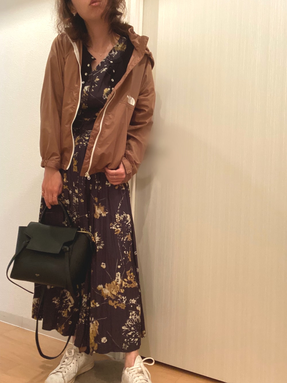 グリーン系のナイロンジャケット、ブラック系のワンピース、ブラック系のカーディガン/ボレロを着用したレディースの春コーディネートの3枚目の写真