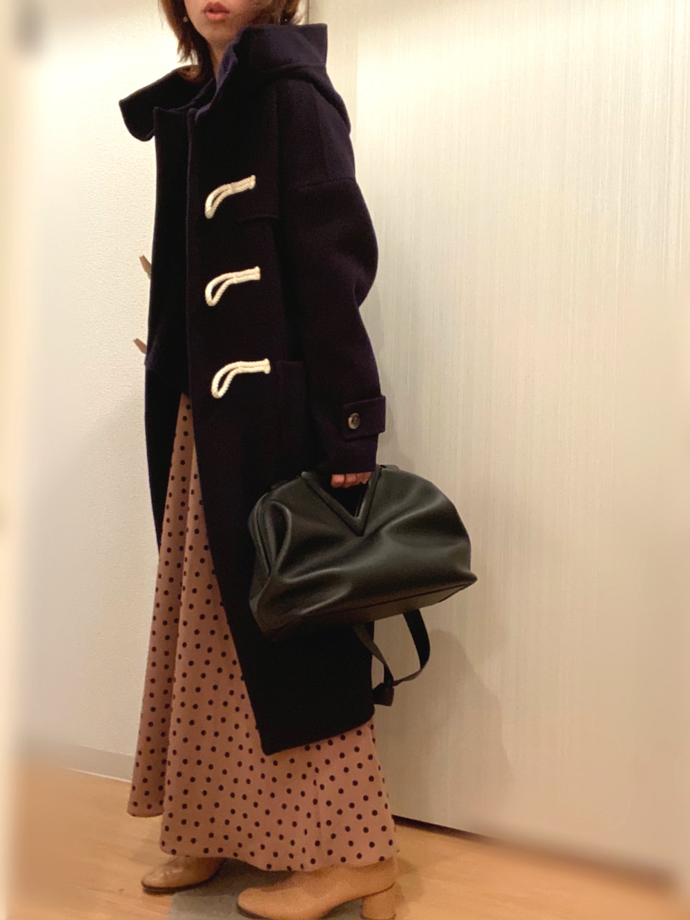 ブルー系のダッフルコート、ブラック系のニット/セーター、ベージュ系のスカートを着用したレディースの冬コーディネートの2枚目の写真