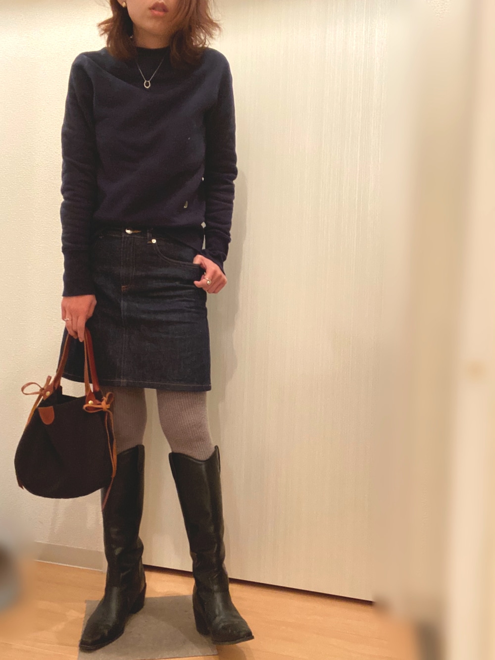 ブルー系のスウェット、ブルー系のデニムスカート、ホワイト系のその他アウターを着用したレディースの冬コーディネートの3枚目の写真