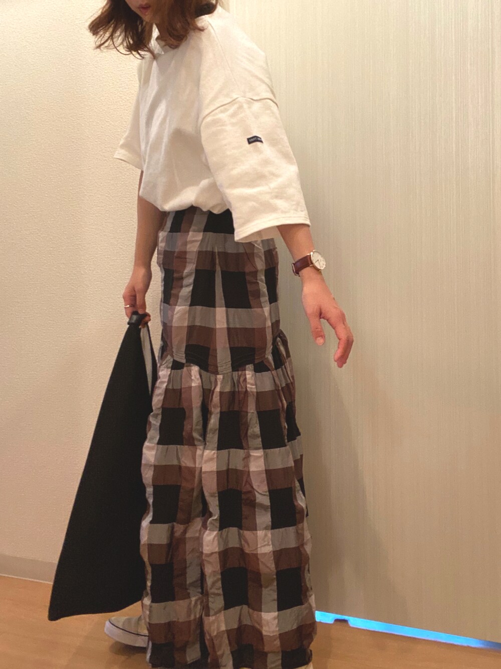 ホワイト系のTシャツ/カットソー、ブラック系のスカート、ブラック系のハンドバッグを着用したレディースの秋コーディネートの2枚目の写真