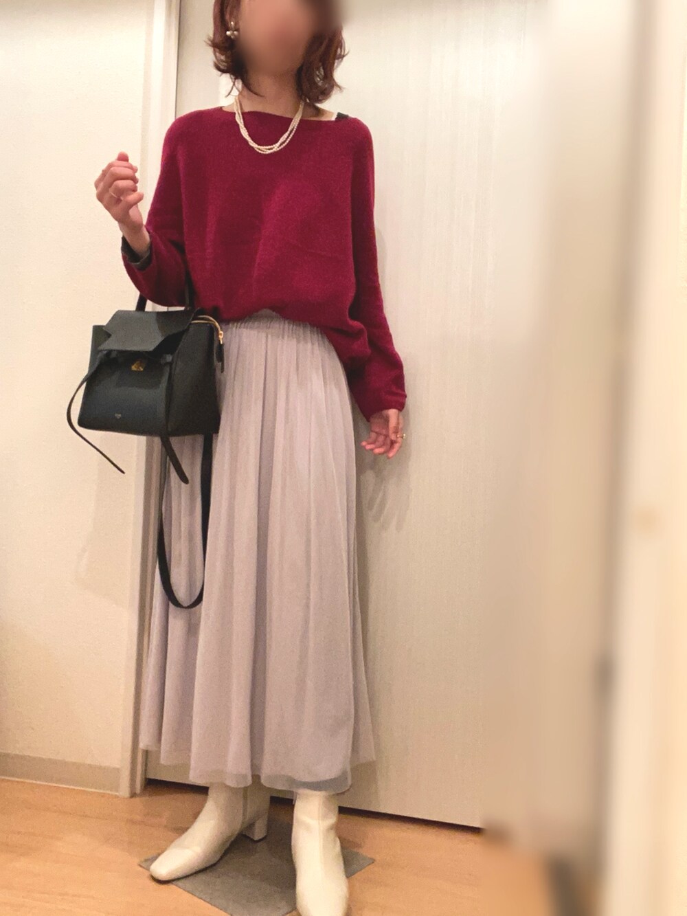 レッド系のニット/セーター、グレー系のスカート、グレー系のムートンコートを着用したレディースの冬コーディネートの4枚目の写真