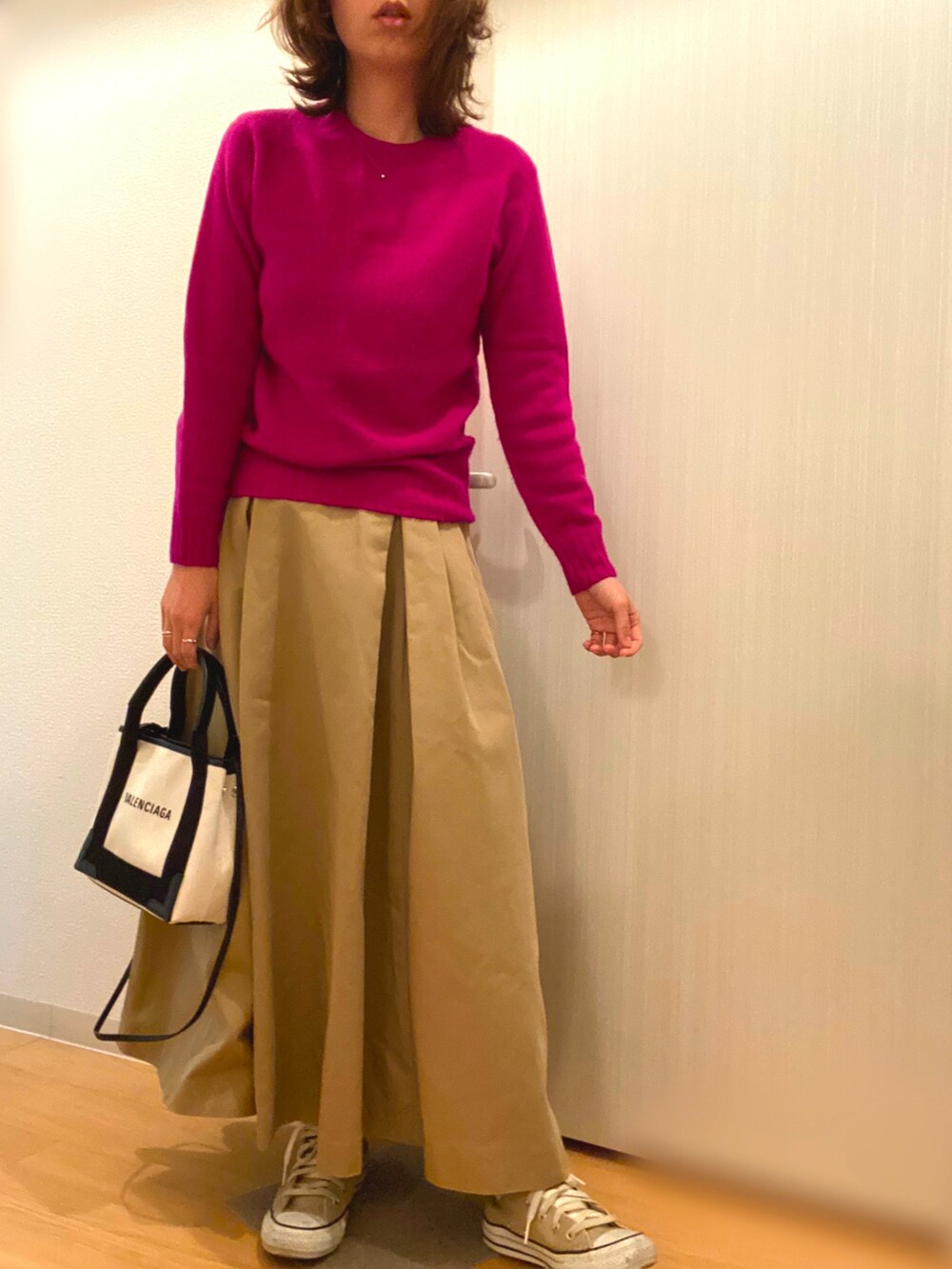 パープル系のニット/セーター、グリーン系のスカート、ベージュ系のスニーカーを着用したレディースの冬コーディネートの3枚目の写真