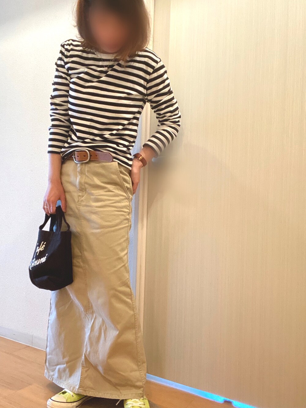 ブラック系のTシャツ/カットソー、ベージュ系のスカート、イエロー系のスニーカーを着用したレディースの春コーディネートの4枚目の写真