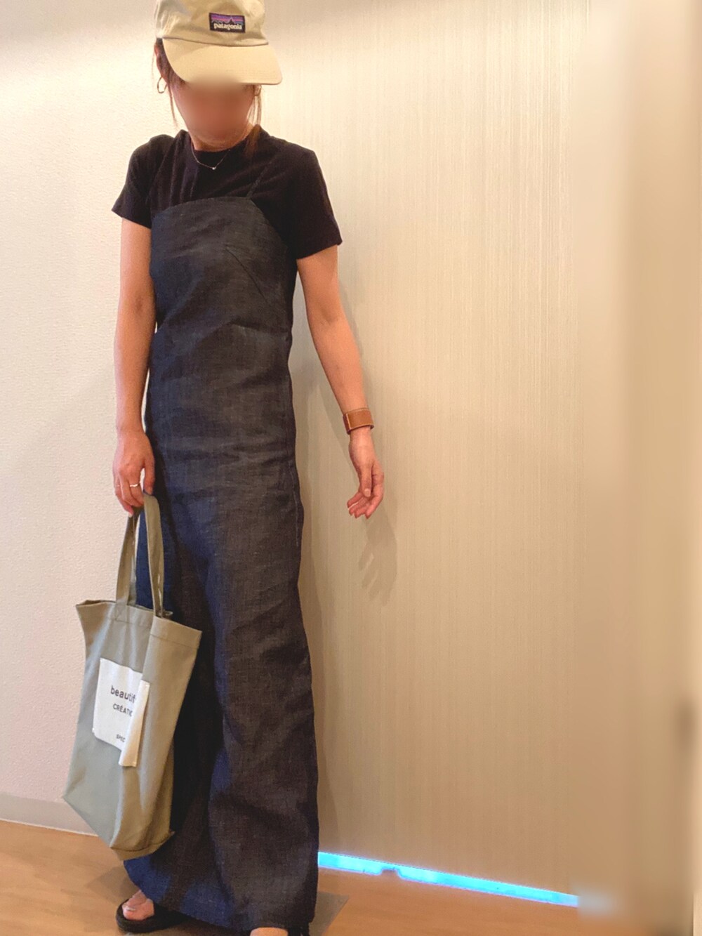 ブラック系のTシャツ/カットソー、ブルー系のワンピース、グリーン系のトートバッグを着用したレディースの夏コーディネートの2枚目の写真