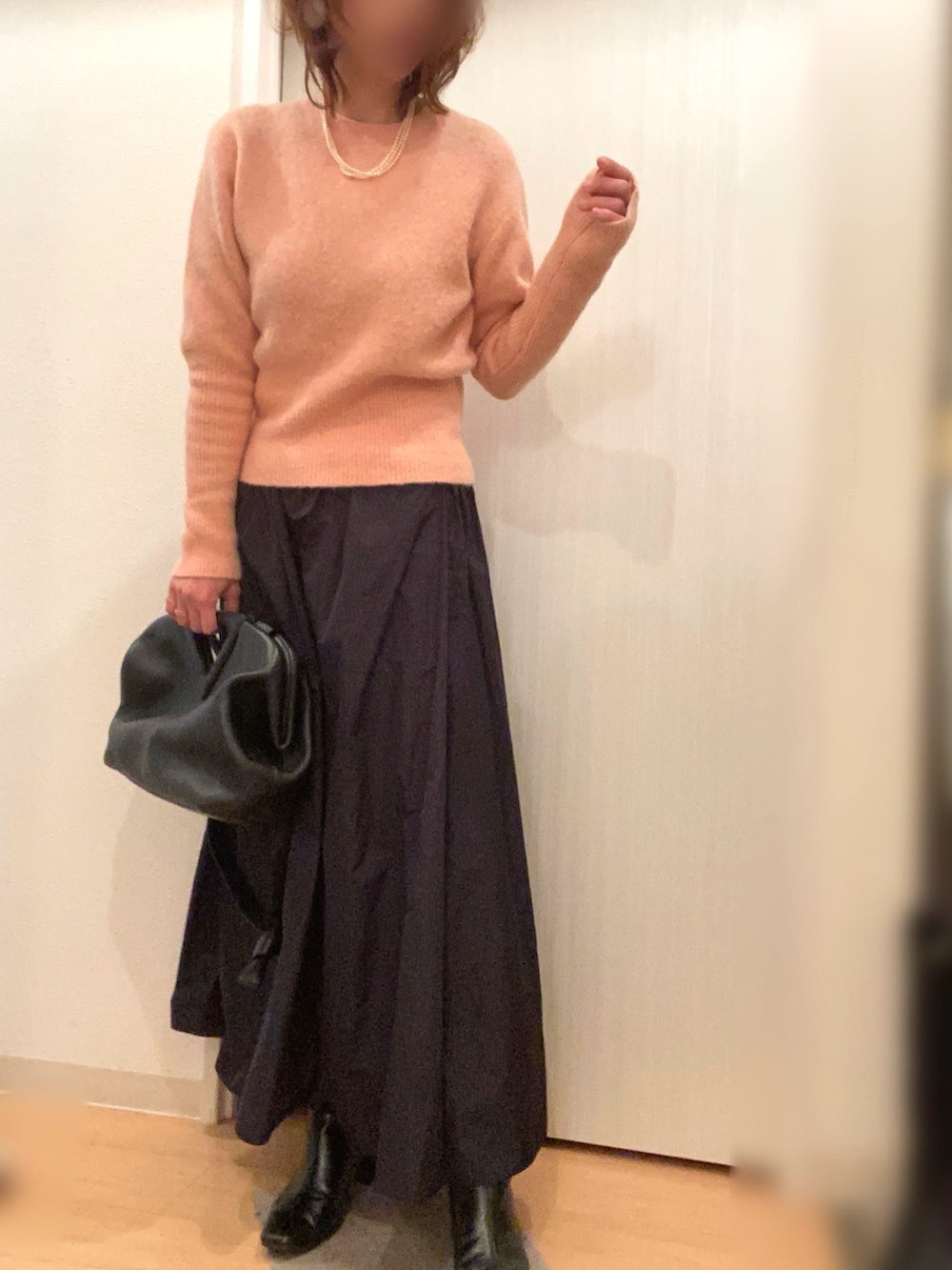 ブルー系のダッフルコート、ピンク系のニット/セーター、ブラック系のスカートを着用したレディースの冬コーディネートの3枚目の写真