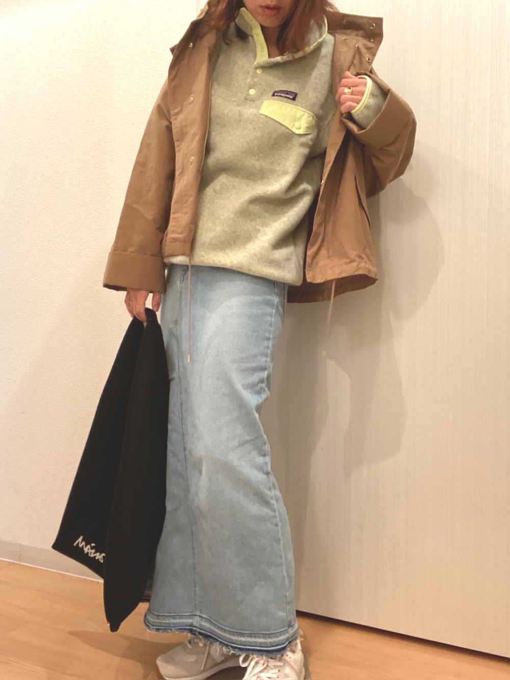 イエロー系のトップス、ブルー系のデニムスカート、ブラック系のハンドバッグを着用したレディースの秋コーディネートの5枚目の写真