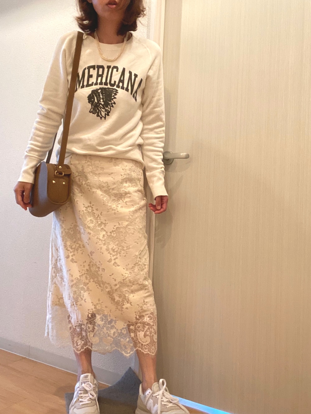ホワイト系のスカート、グレー系のスニーカー、ベージュ系のショルダーバッグを着用したレディースの春コーディネートの3枚目の写真