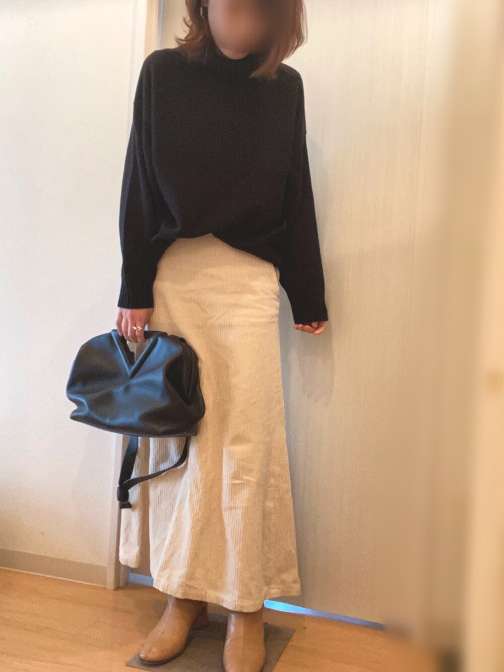 グリーン系のジャケット/アウター、ブラック系のニット/セーター、ホワイト系のスカートを着用したレディースの冬コーディネートの3枚目の写真