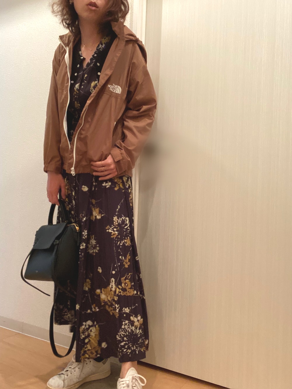 グリーン系のナイロンジャケット、ブラック系のワンピース、ブラック系のカーディガン/ボレロを着用したレディースの春コーディネートの2枚目の写真