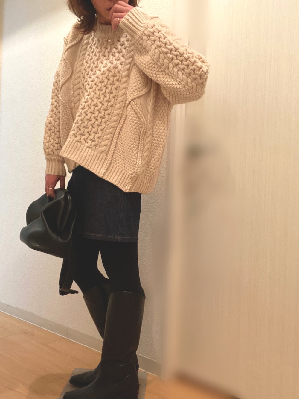 ホワイト系のニット/セーター、ブルー系のデニムスカート、ブラック系のブーツを着用したレディースの冬コーディネートの4枚目の写真