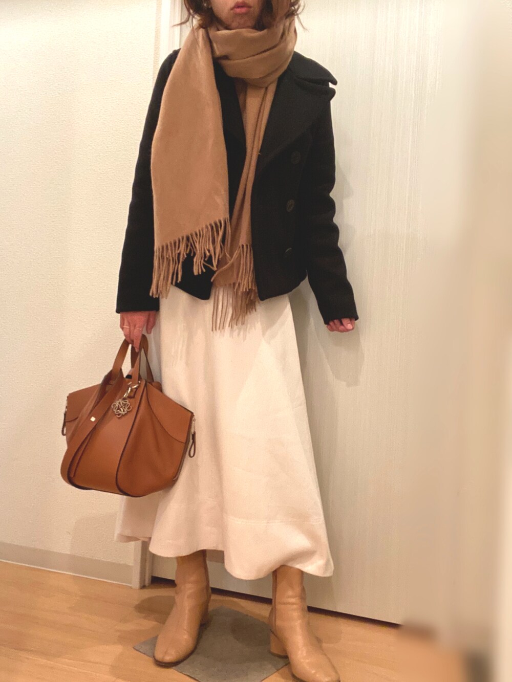 ブラウン系のニット/セーター、ベージュ系のスカート、その他のジャケット/アウターを着用したレディースの冬コーディネートの2枚目の写真