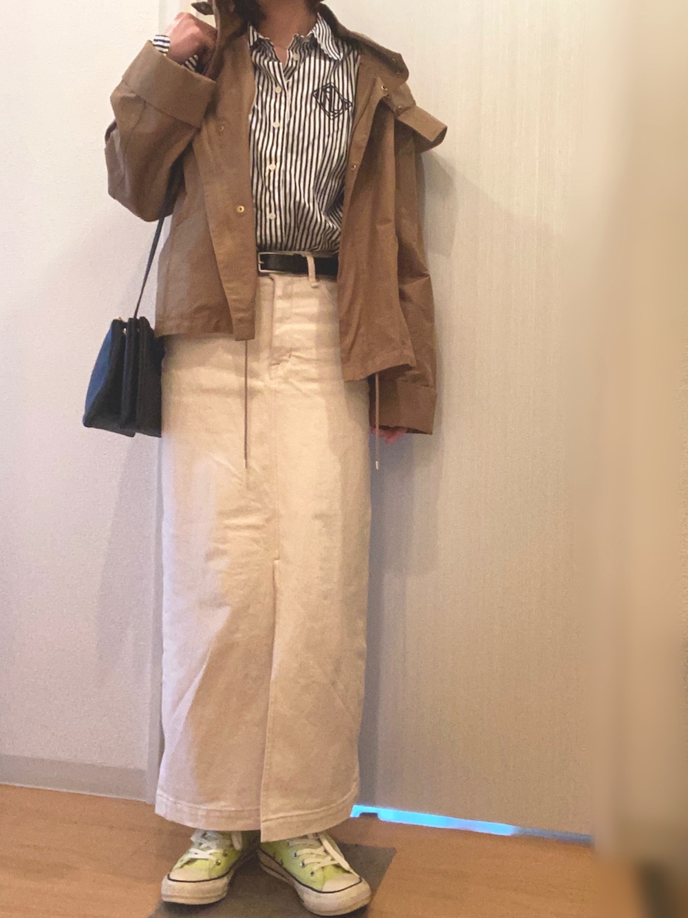 ブラック系のシャツ/ブラウス、ホワイト系のデニムスカート、イエロー系のスニーカーを着用したレディースの春コーディネートの4枚目の写真