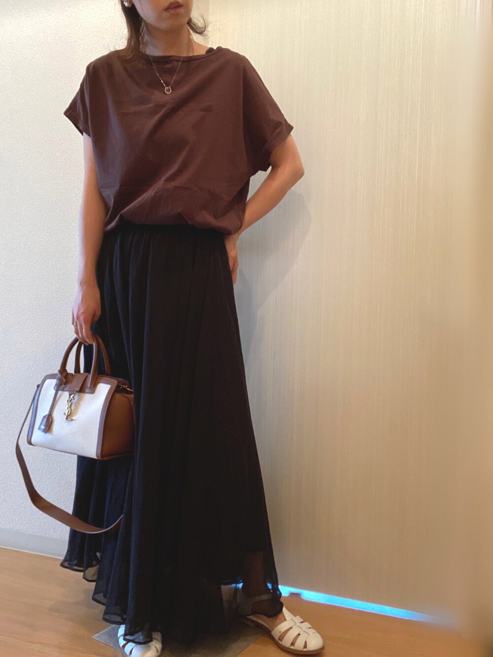 ブラウン系のTシャツ/カットソー、ブラック系のスカート、ホワイト系のサンダルを着用したレディースの夏コーディネートの3枚目の写真