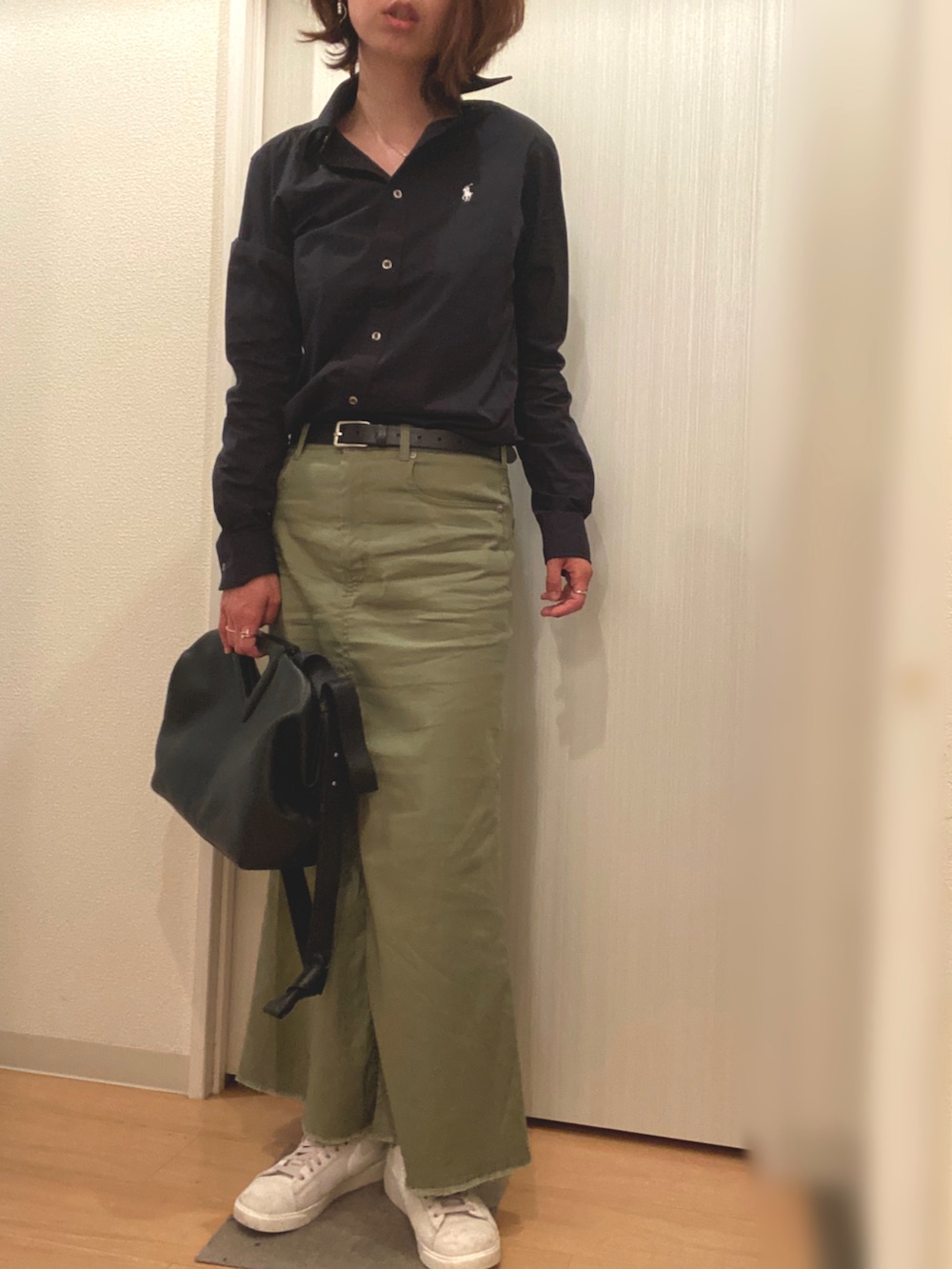 ブラック系のシャツ/ブラウス、グリーン系のスカート、ブラック系のバッグを着用したレディースの夏コーディネートの2枚目の写真