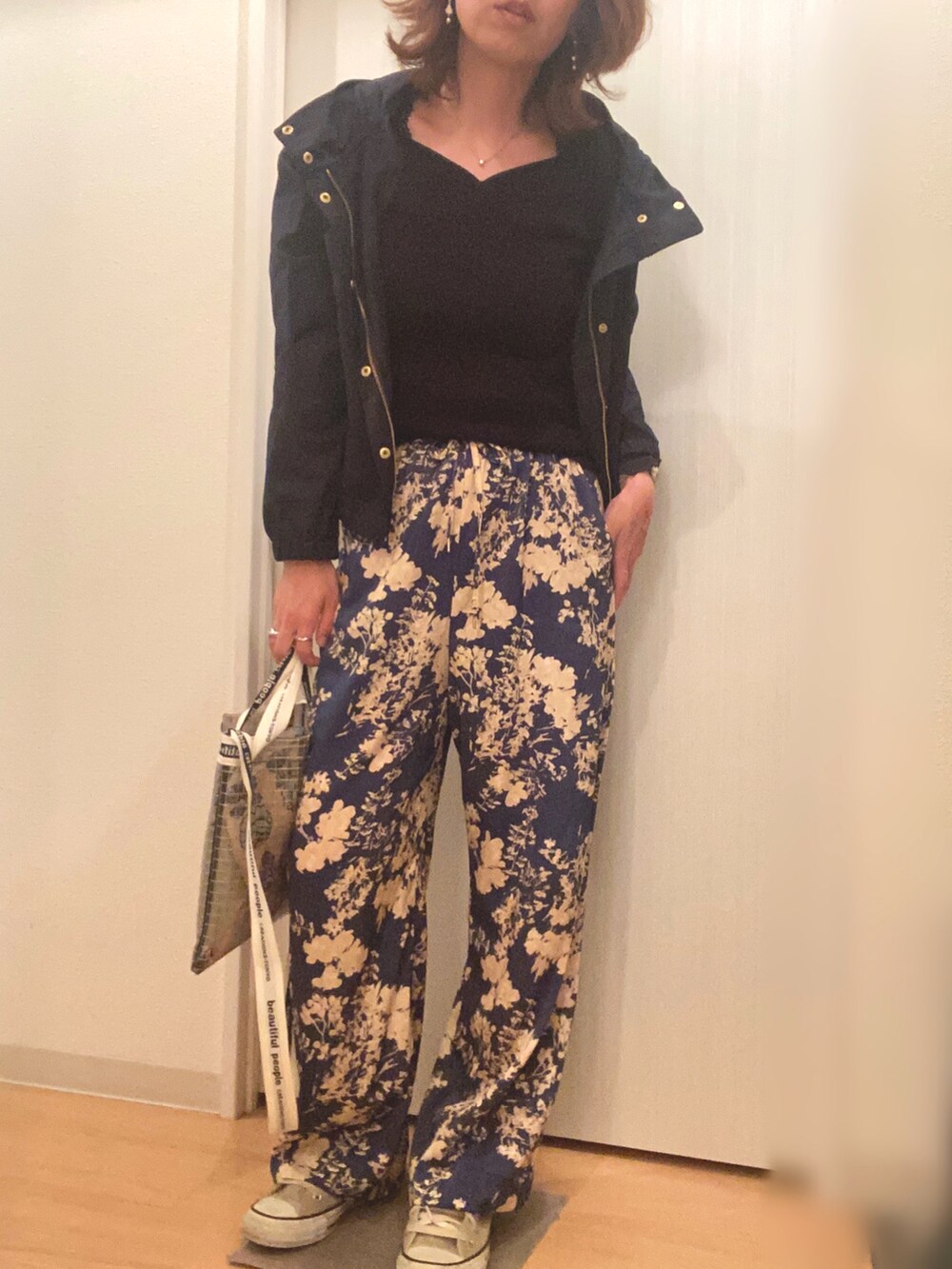 ブラック系のニット/セーター、ブルー系のその他パンツ、ベージュ系のスニーカーを着用したレディースの秋コーディネートの2枚目の写真