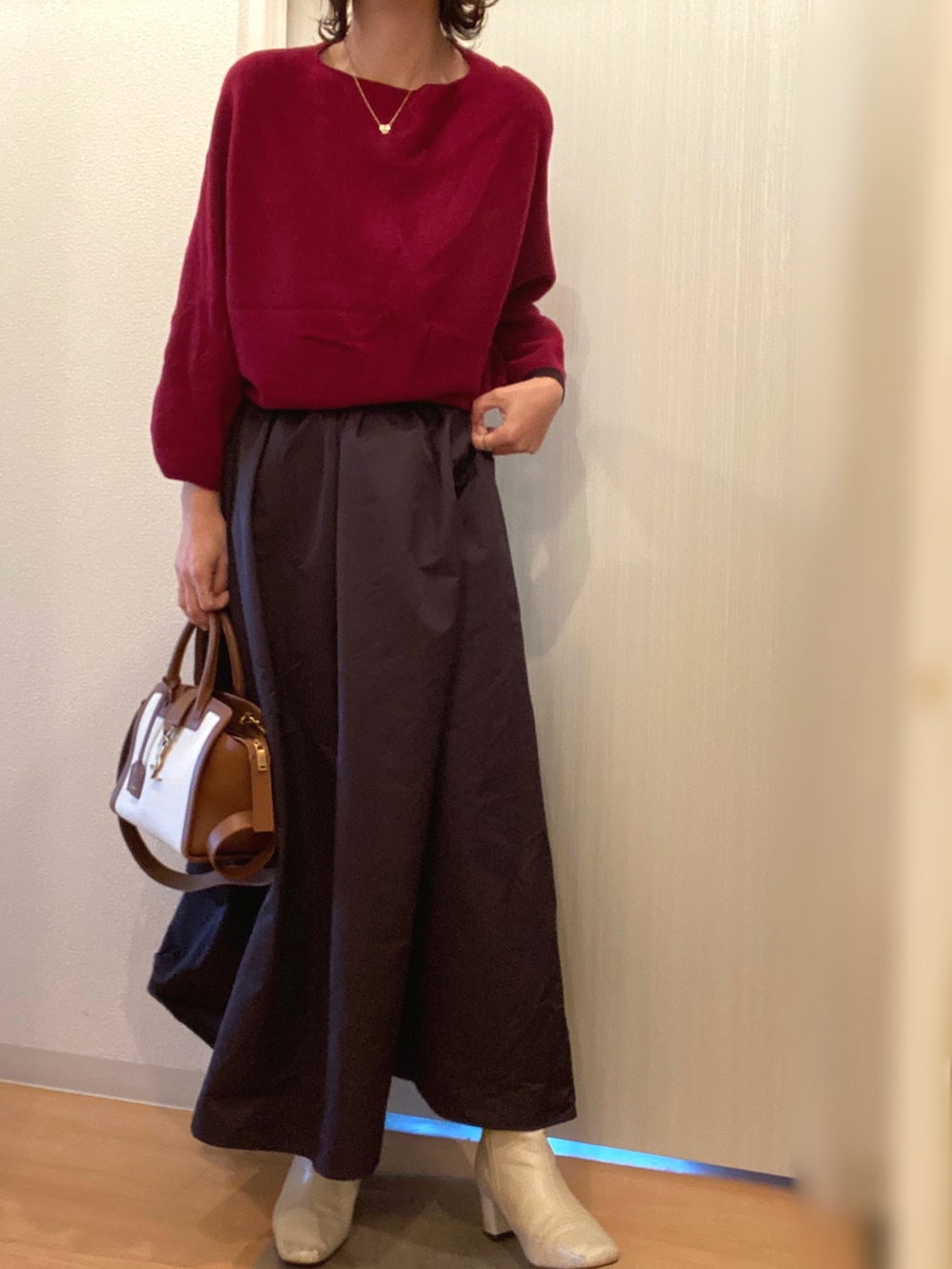 レッド系のニット/セーター、その他のスカート、ベージュ系のブーツを着用したレディースの冬コーディネートの4枚目の写真