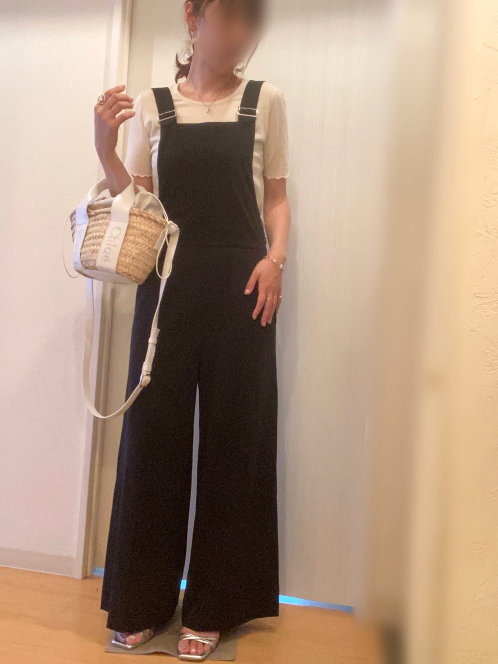 ホワイト系のTシャツ/カットソー、ブラック系のサロペット/オーバーオール、シルバー系のサンダルを着用したレディースの夏コーディネートの2枚目の写真