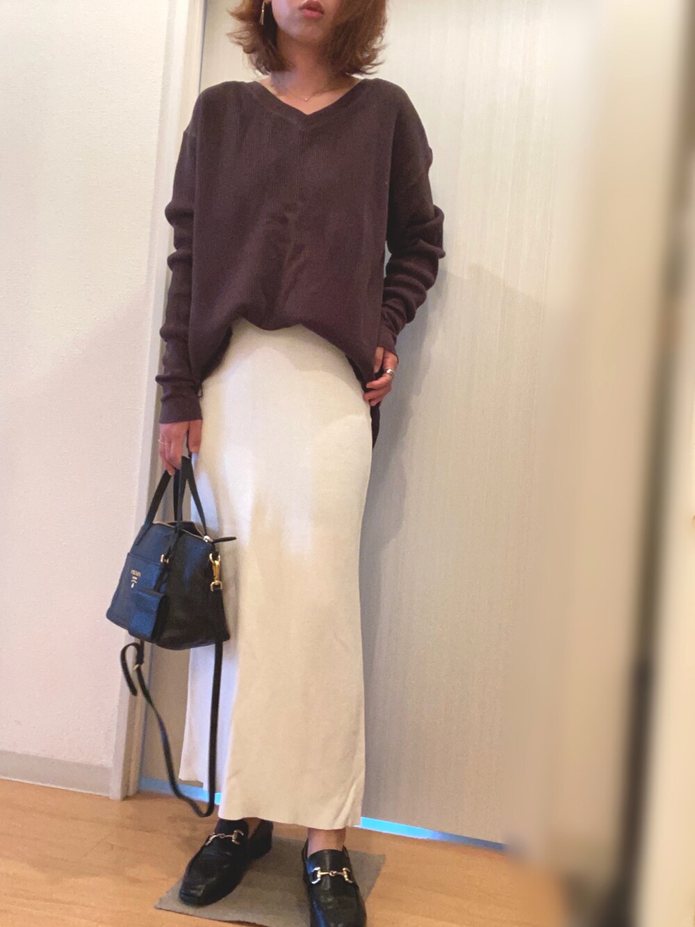 グレー系のTシャツ/カットソー、ホワイト系のスカート、ブラック系のローファーを着用したレディースの秋コーディネートの2枚目の写真