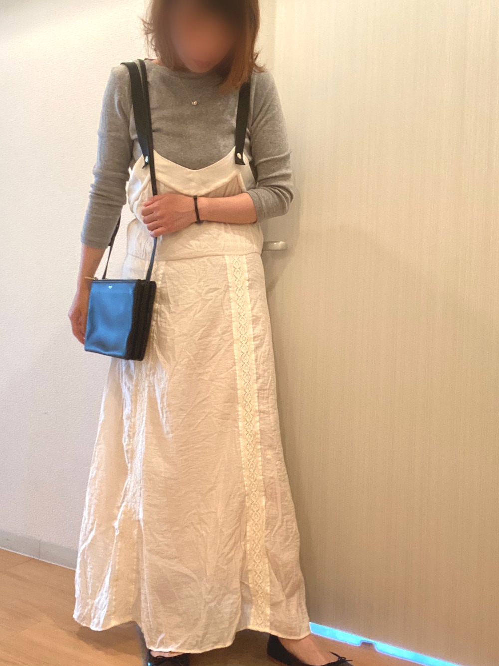 グレー系のTシャツ/カットソー、ホワイト系のジャンパースカート、ブラック系のバレエシューズを着用したレディースの夏コーディネートの2枚目の写真