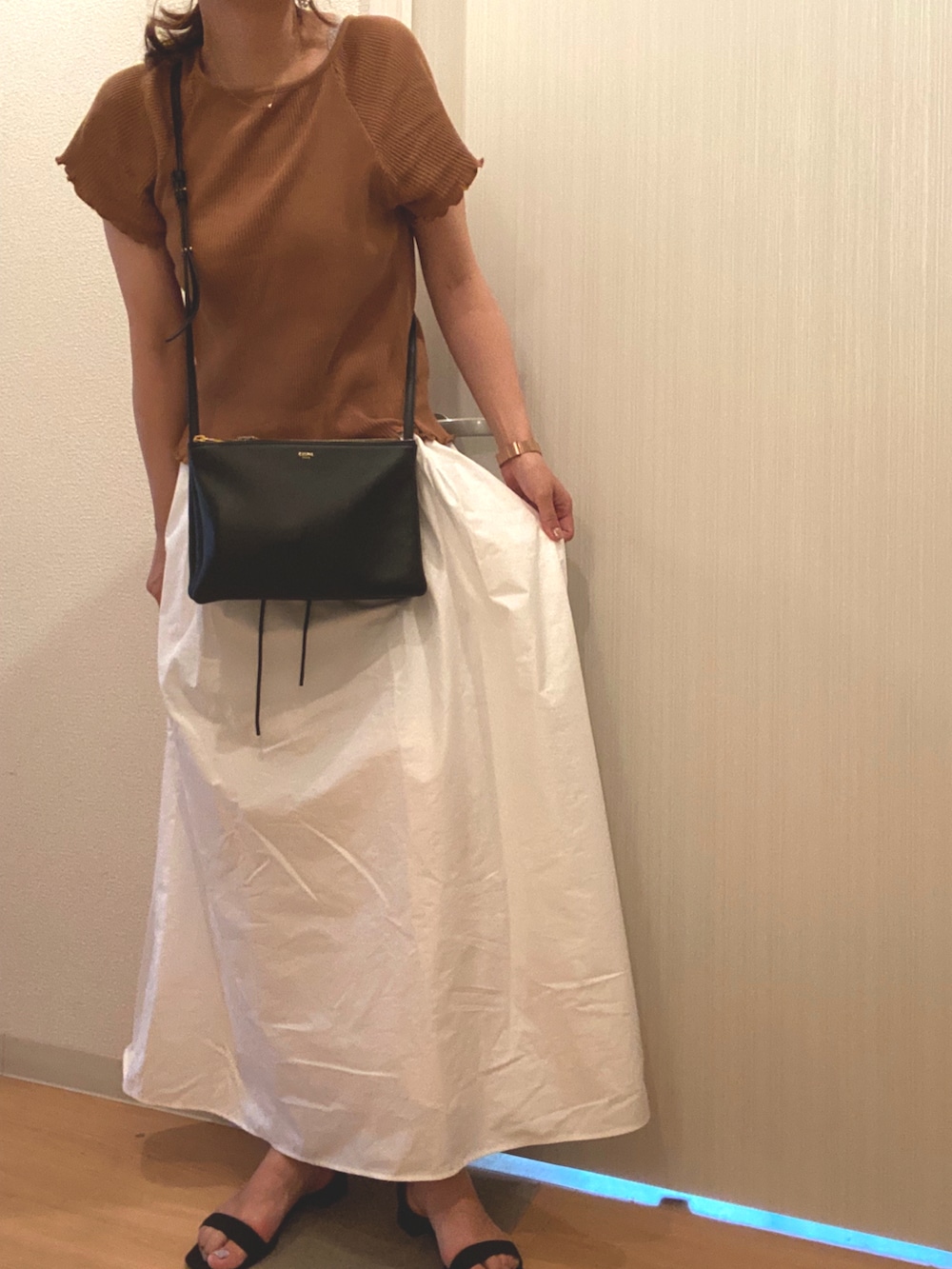 ベージュ系のTシャツ/カットソー、ホワイト系のスカート、ブラック系のサンダルを着用したレディースの夏コーディネートの2枚目の写真