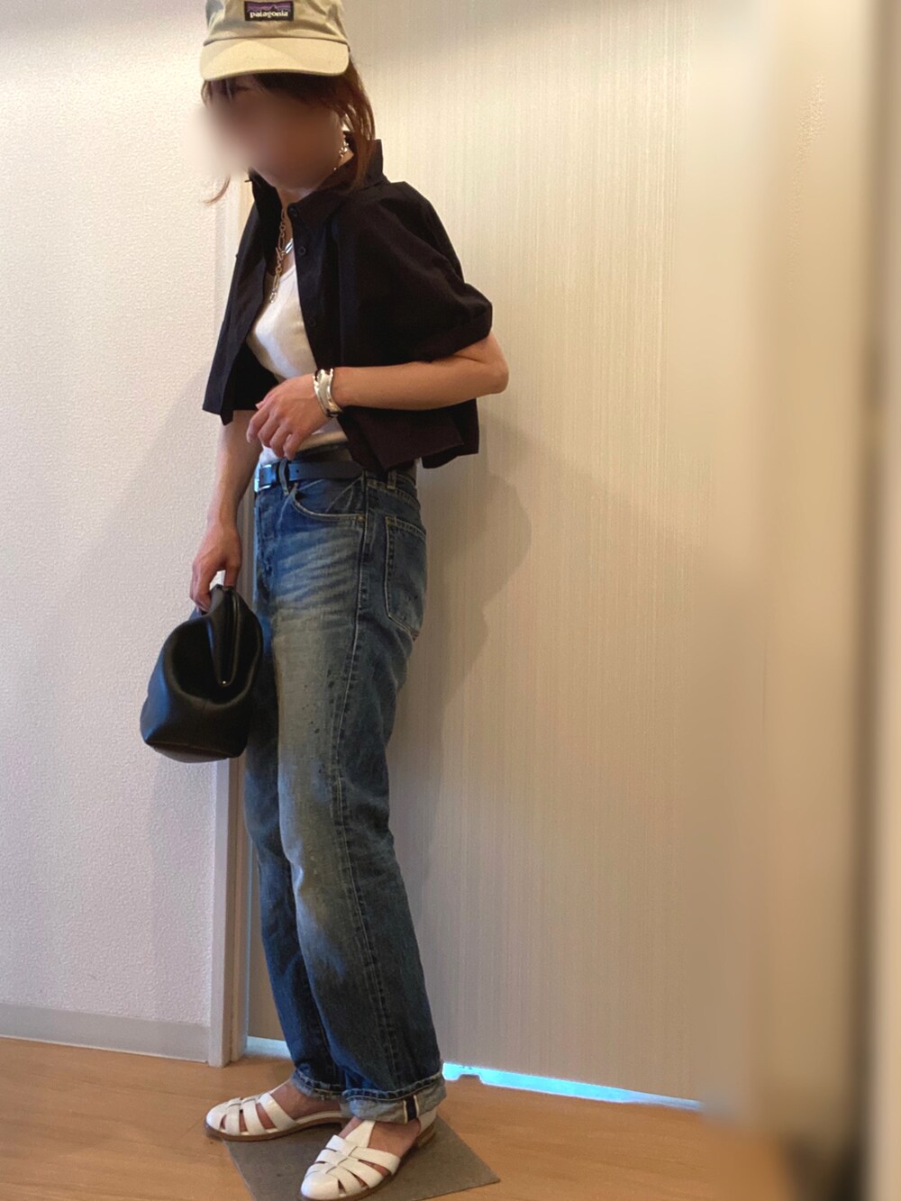 ホワイト系のタンクトップ、ブルー系のデニムパンツ、ホワイト系のサンダルを着用したレディースの夏コーディネートの3枚目の写真