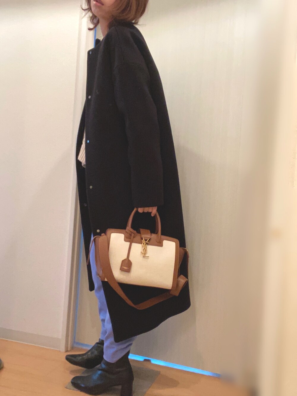 ホワイト系のニット/セーター、ブルー系のその他パンツ、ブラック系のステンカラーコートを着用したレディースの冬コーディネートの3枚目の写真