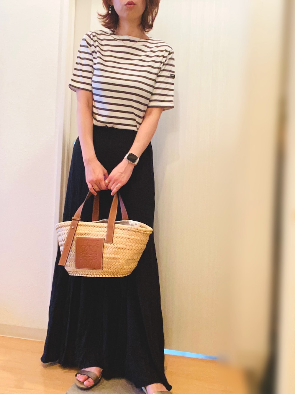 ブラウン系のTシャツ/カットソー、ブラック系のスカート、ベージュ系のかごバッグを着用したレディースの夏コーディネートの2枚目の写真