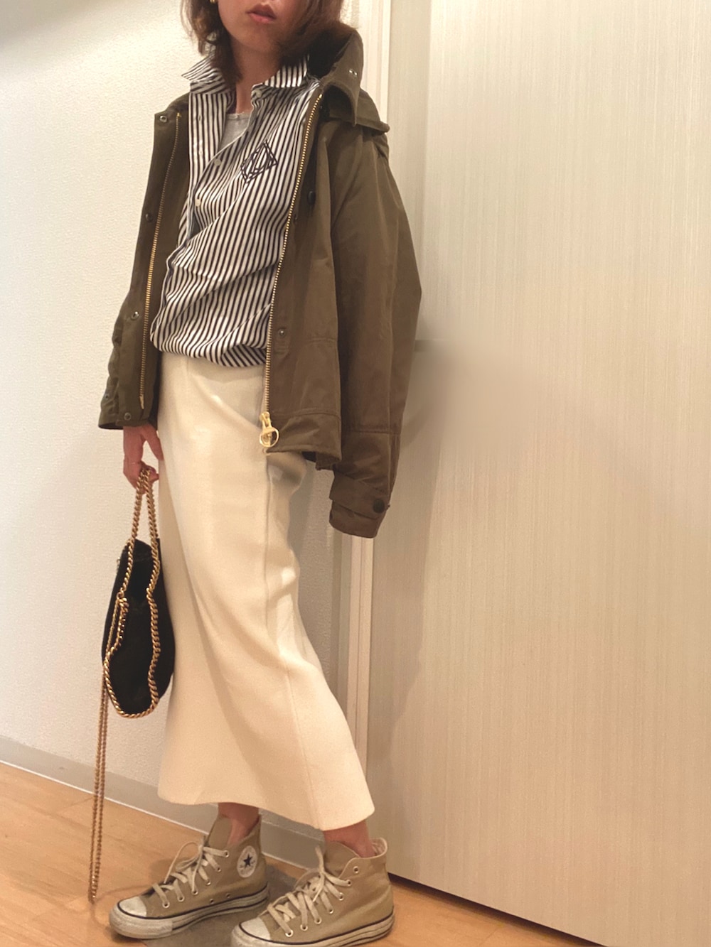 グリーン系のその他アウター、ブラック系のシャツ/ブラウス、ホワイト系のスカートを着用したレディースの春コーディネートの2枚目の写真