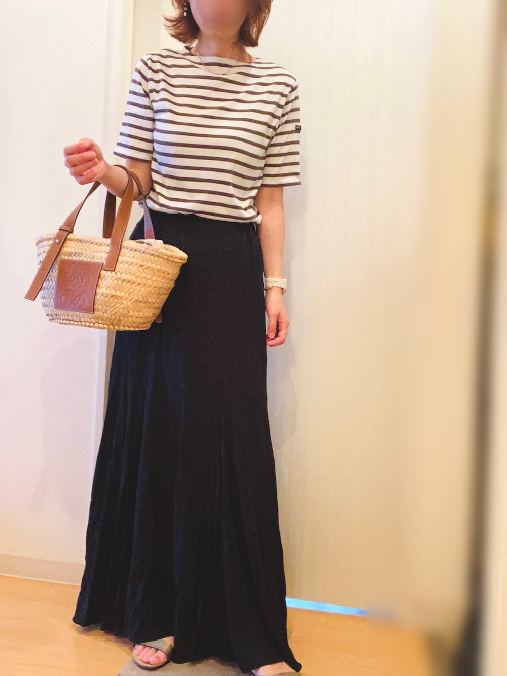 ブラウン系のTシャツ/カットソー、ブラック系のスカート、ベージュ系のかごバッグを着用したレディースの夏コーディネートの3枚目の写真