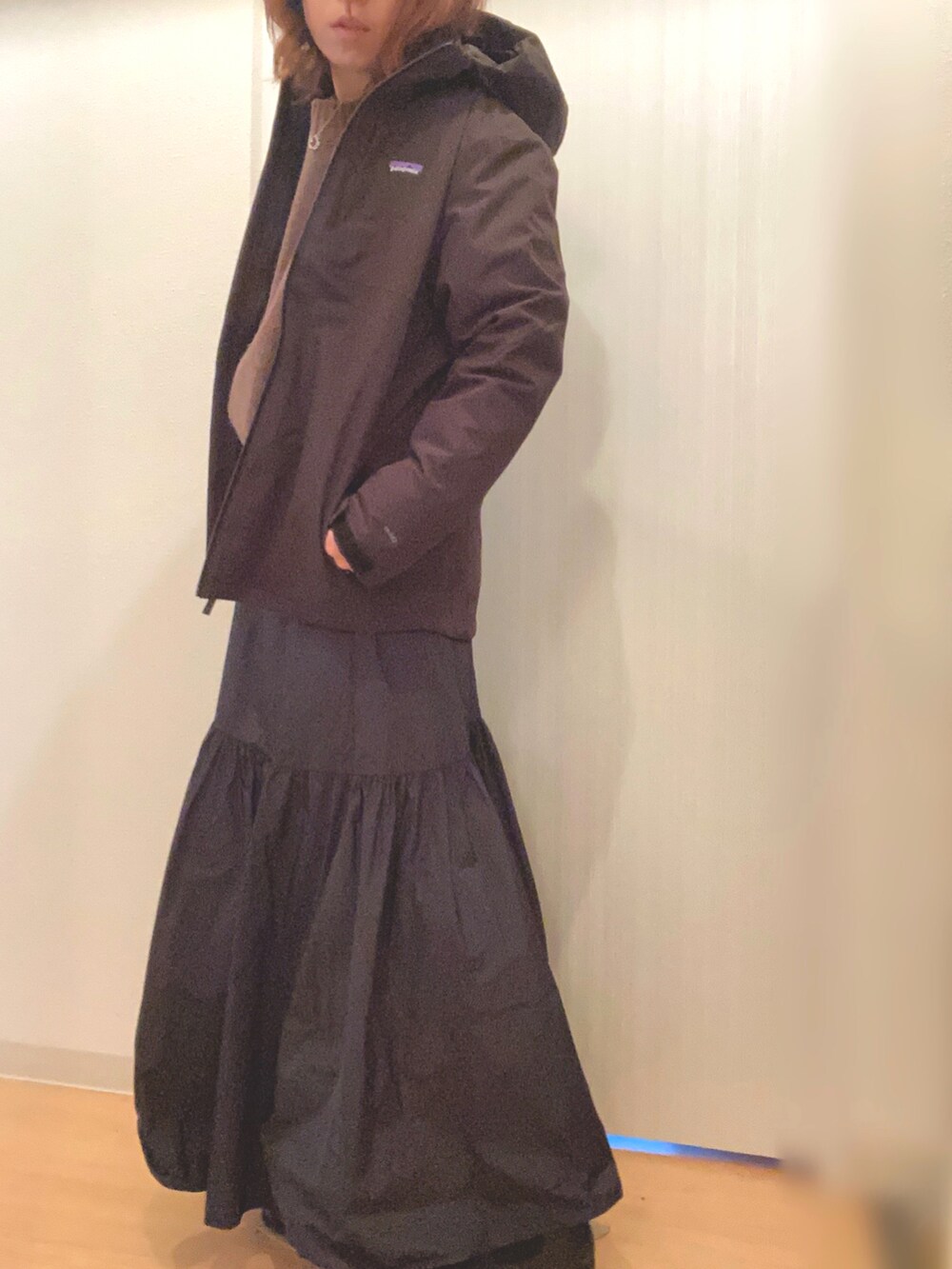 ブラウン系のニット/セーター、ブラック系のスカート、グリーン系のトートバッグを着用したレディースの冬コーディネートの2枚目の写真