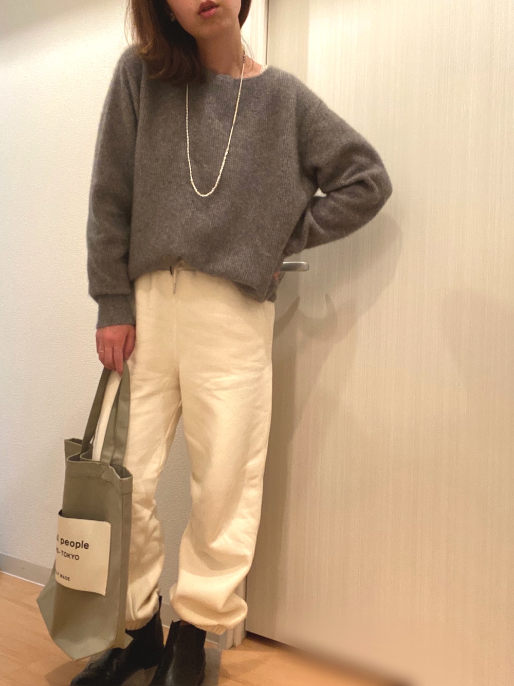 ブルー系のその他アウター、グレー系のニット/セーター、ホワイト系のスウェットパンツを着用したレディースの冬コーディネートの2枚目の写真