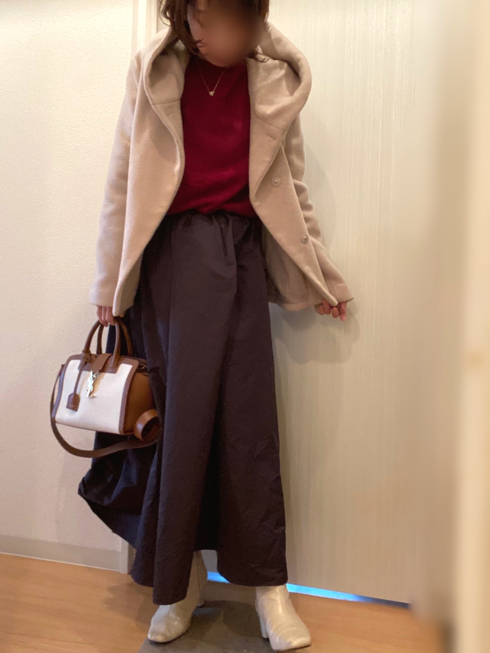 レッド系のニット/セーター、その他のスカート、ベージュ系のブーツを着用したレディースの冬コーディネートの3枚目の写真