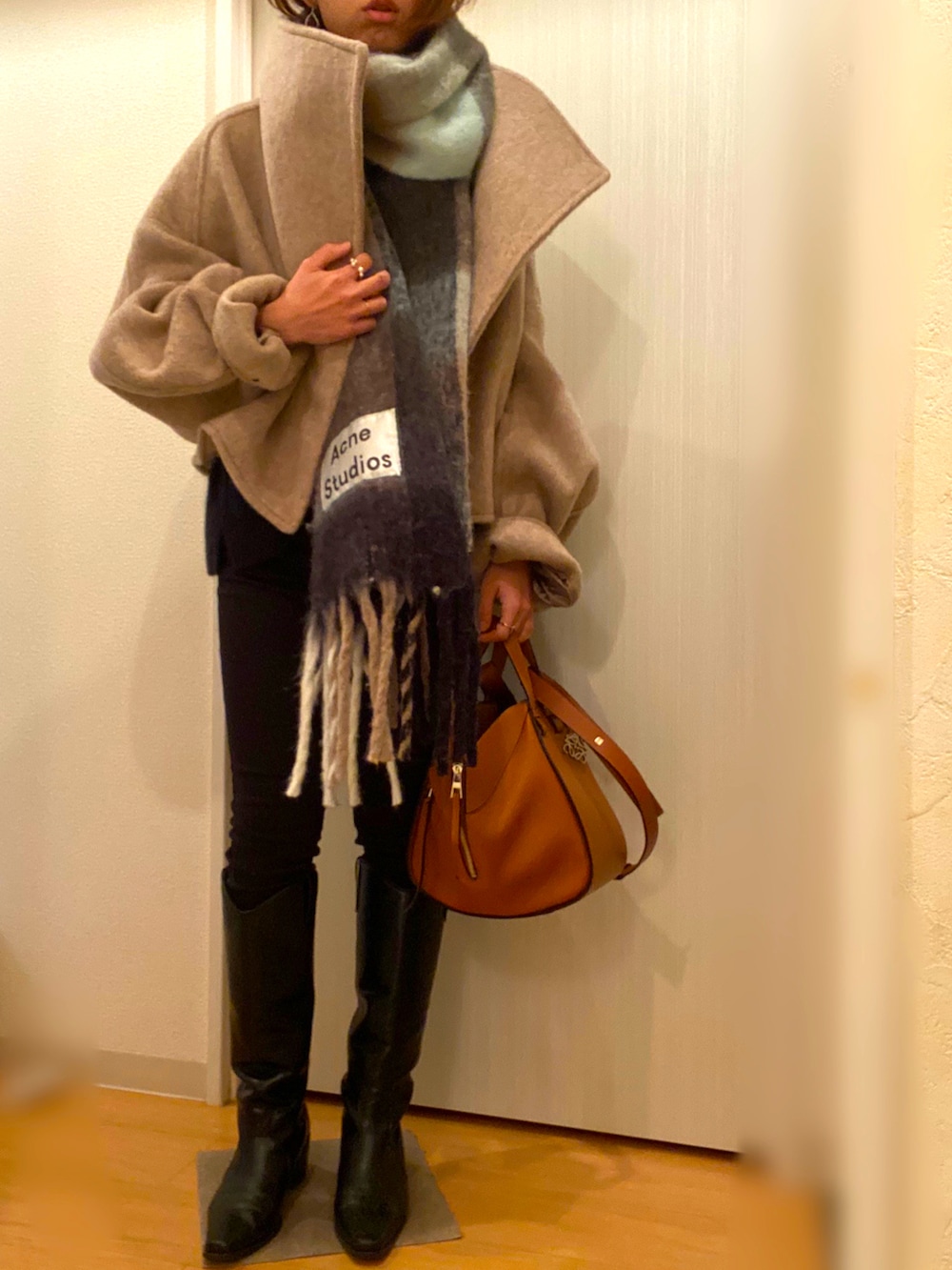 ベージュ系のその他アウター、ブラック系のニット/セーター、ブラック系のデニムパンツを着用したレディースの冬コーディネートの2枚目の写真