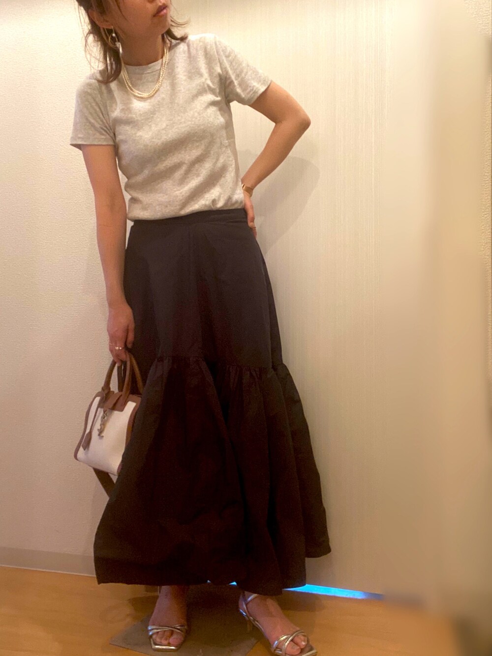 グレー系のTシャツ/カットソー、ブラック系のスカート、シルバー系のサンダルを着用したレディースの夏コーディネートの2枚目の写真