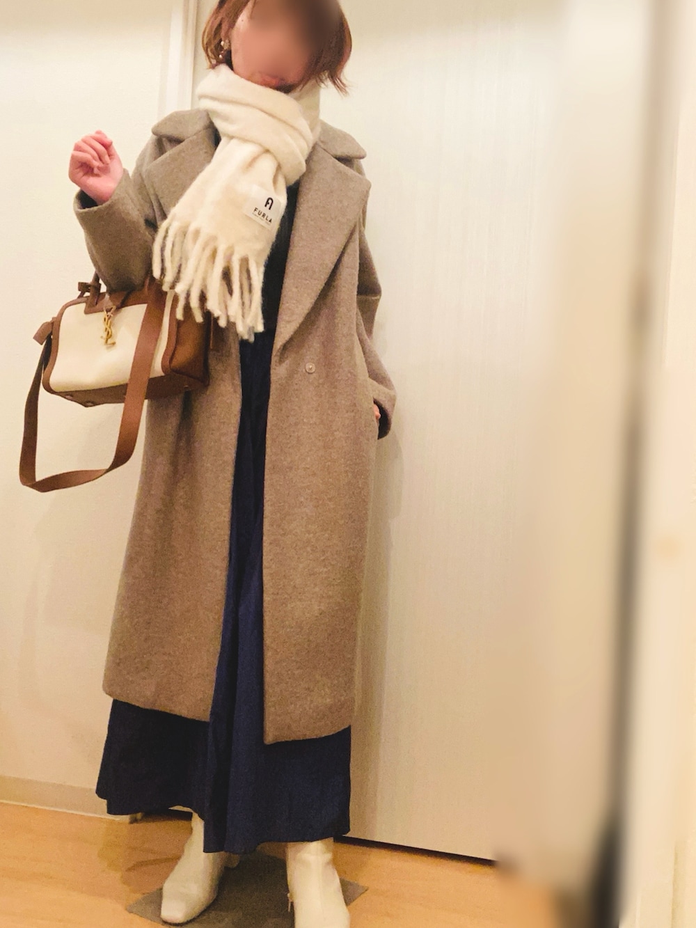 グレー系のニット/セーター、ブルー系のスカート、ベージュ系のブーツを着用したレディースの冬コーディネートの3枚目の写真