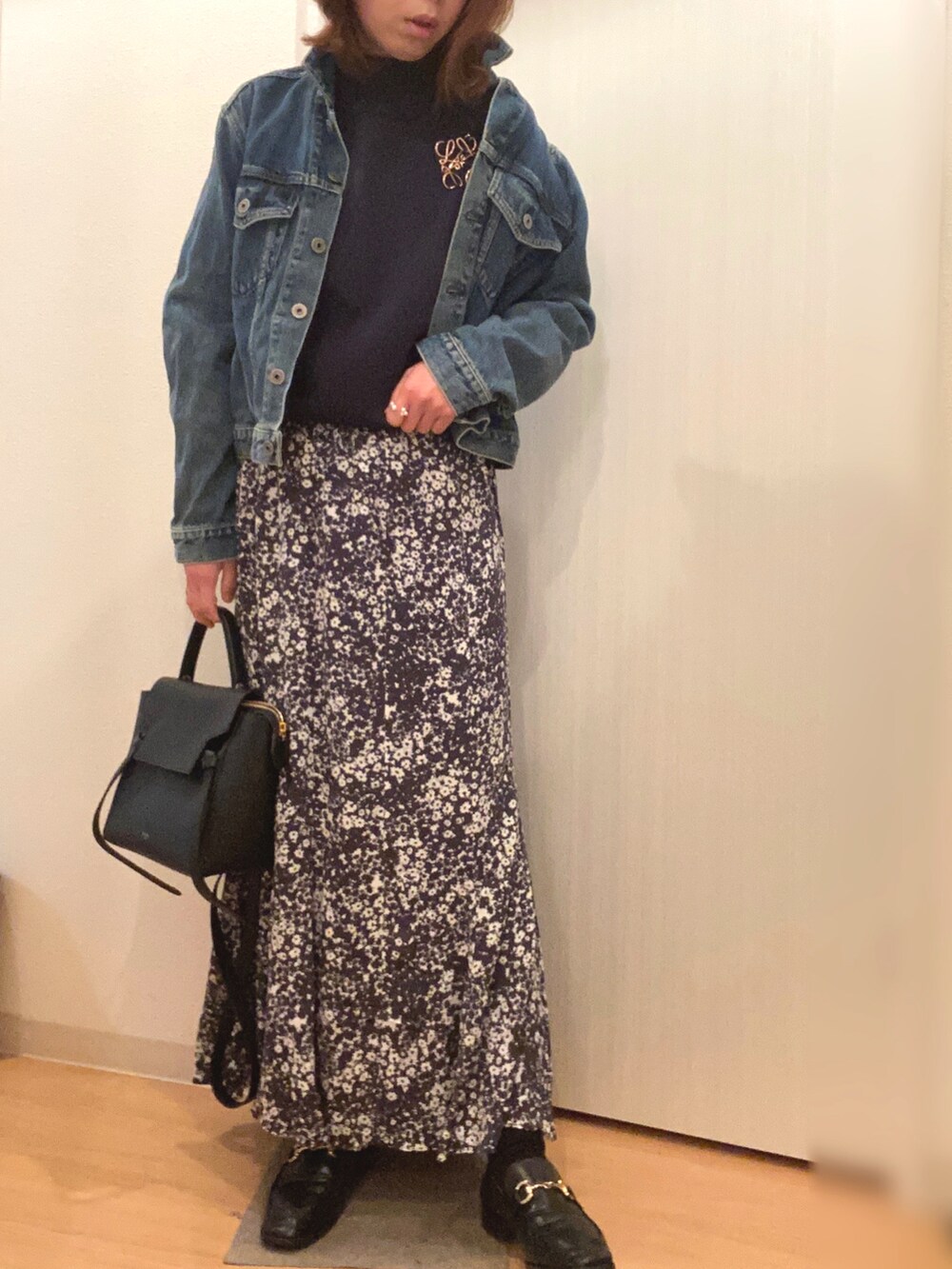 ブルー系のデニムジャケット、ブルー系のニット/セーター、グレー系のスカートを着用したレディースの春コーディネートの3枚目の写真