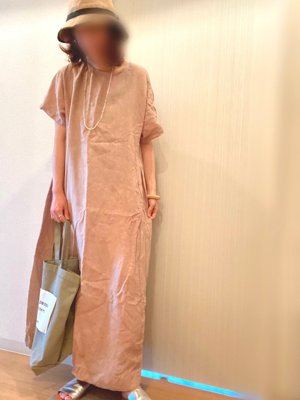 ベージュ系のワンピース、シルバー系のサンダル、グリーン系のトートバッグを着用したレディースの夏コーディネートの2枚目の写真