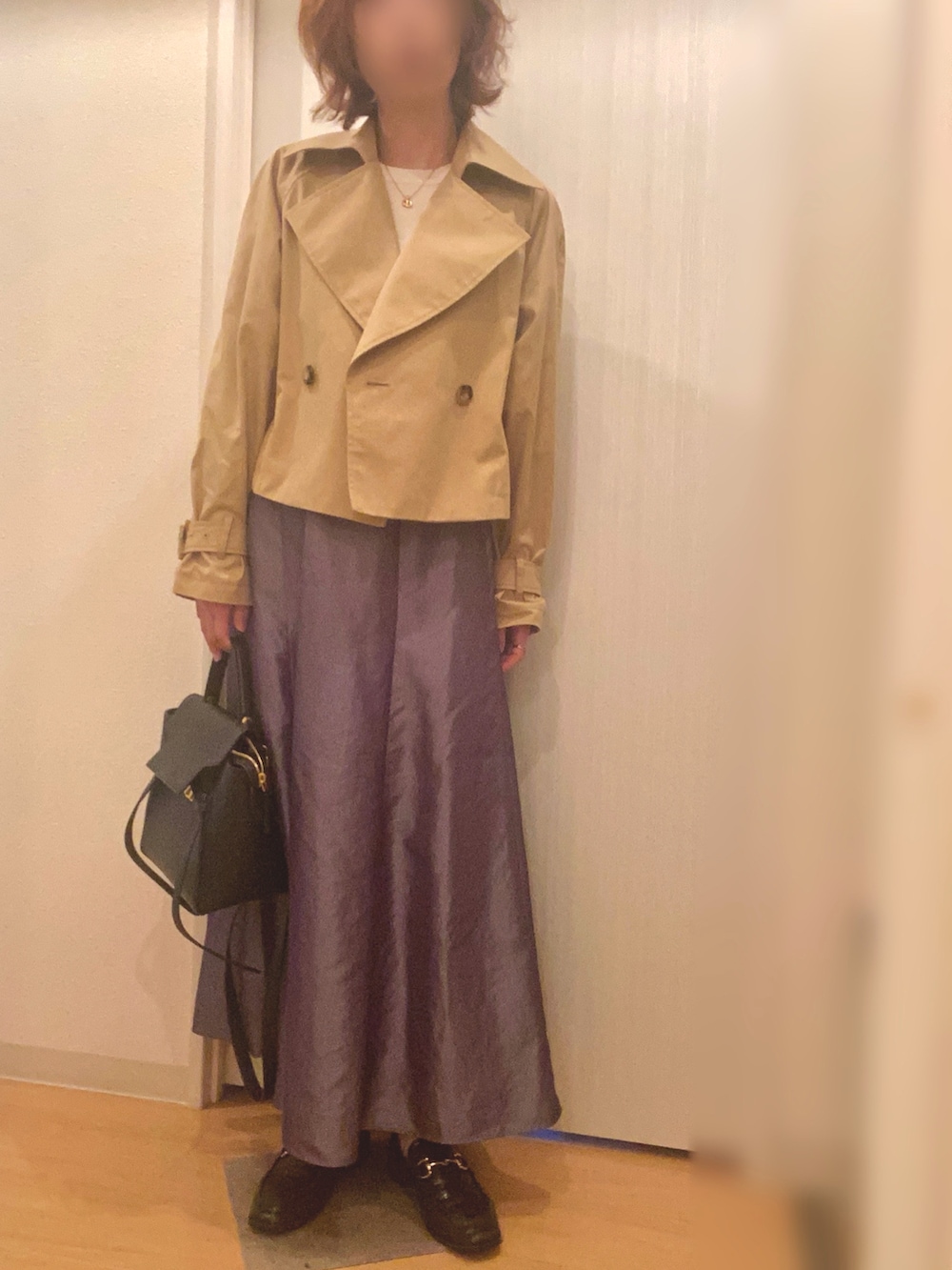 ベージュ系のトレンチコート、ホワイト系のニット/セーター、グレー系のスカートを着用したレディースの春コーディネートの3枚目の写真