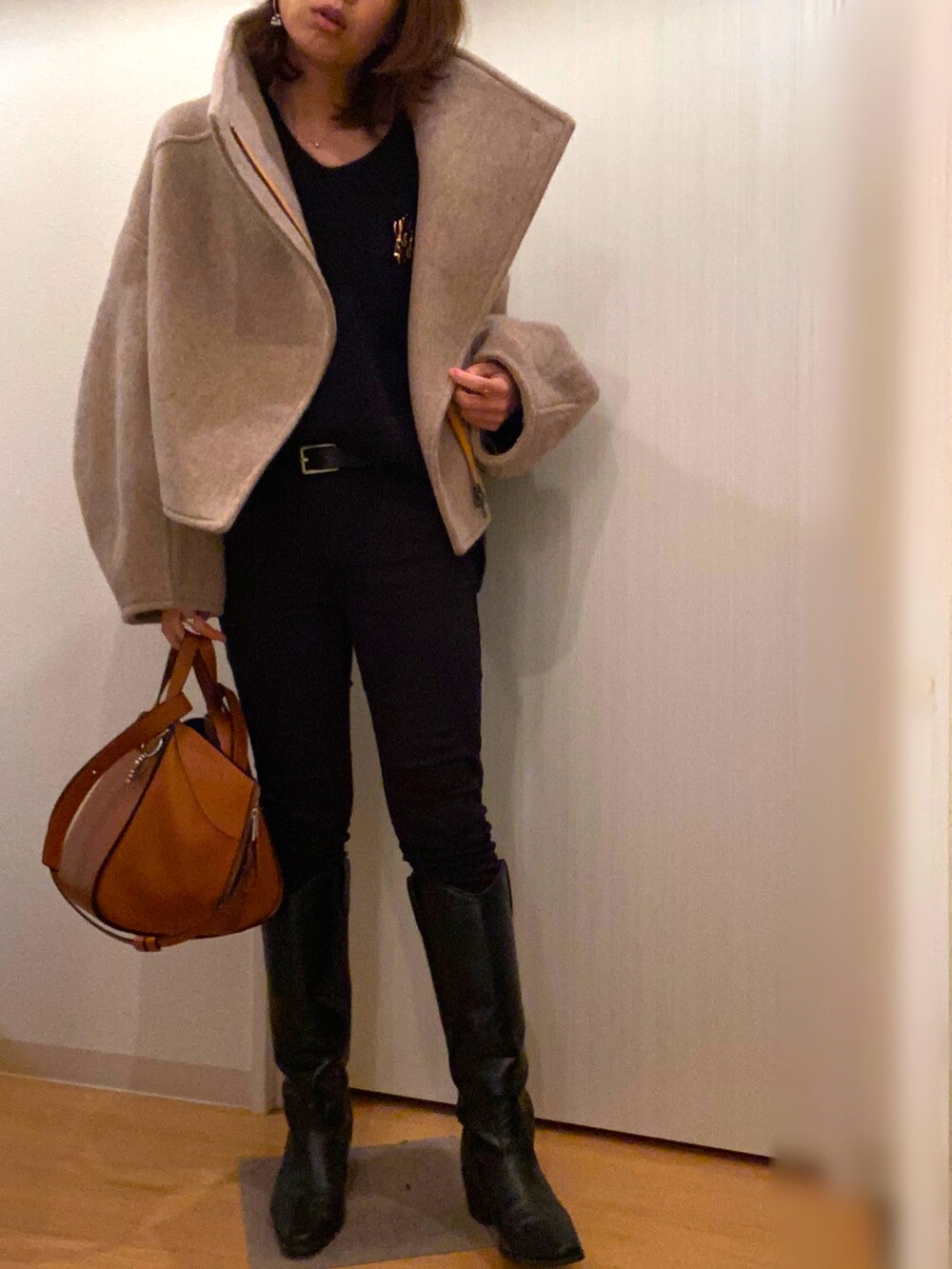 ベージュ系のその他アウター、ブラック系のニット/セーター、ブラック系のデニムパンツを着用したレディースの冬コーディネートの3枚目の写真
