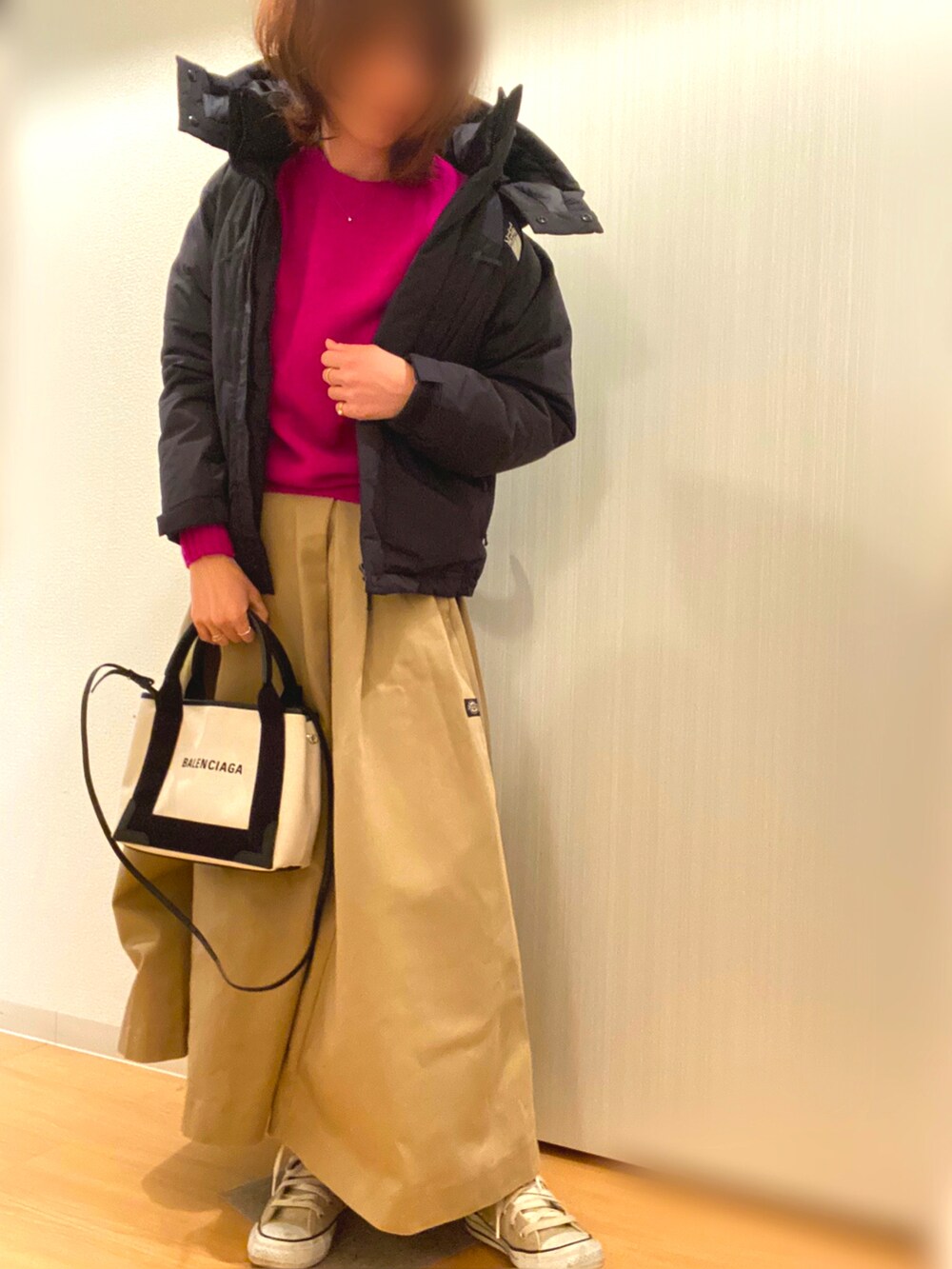 パープル系のニット/セーター、グリーン系のスカート、ベージュ系のスニーカーを着用したレディースの冬コーディネートの2枚目の写真