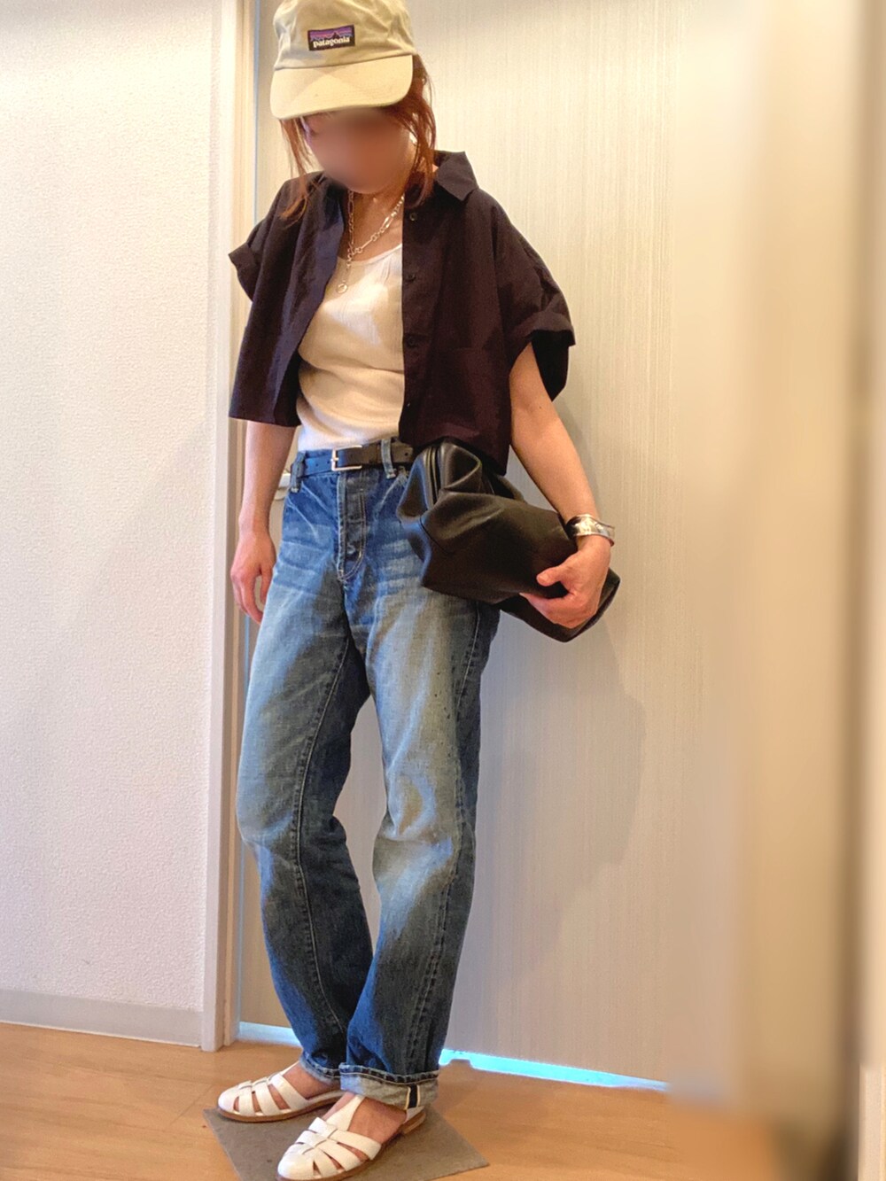 ホワイト系のタンクトップ、ブルー系のデニムパンツ、ホワイト系のサンダルを着用したレディースの夏コーディネートの2枚目の写真