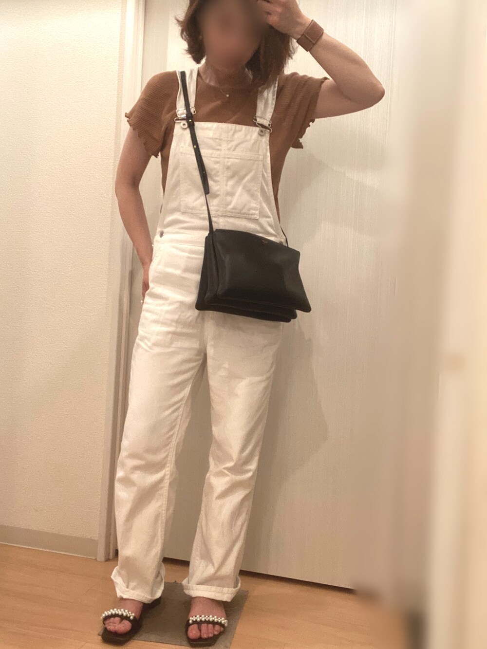 ホワイト系のサロペット/オーバーオール、ブラック系のサンダル、ブラック系のショルダーバッグを着用したレディースの夏コーディネートの2枚目の写真