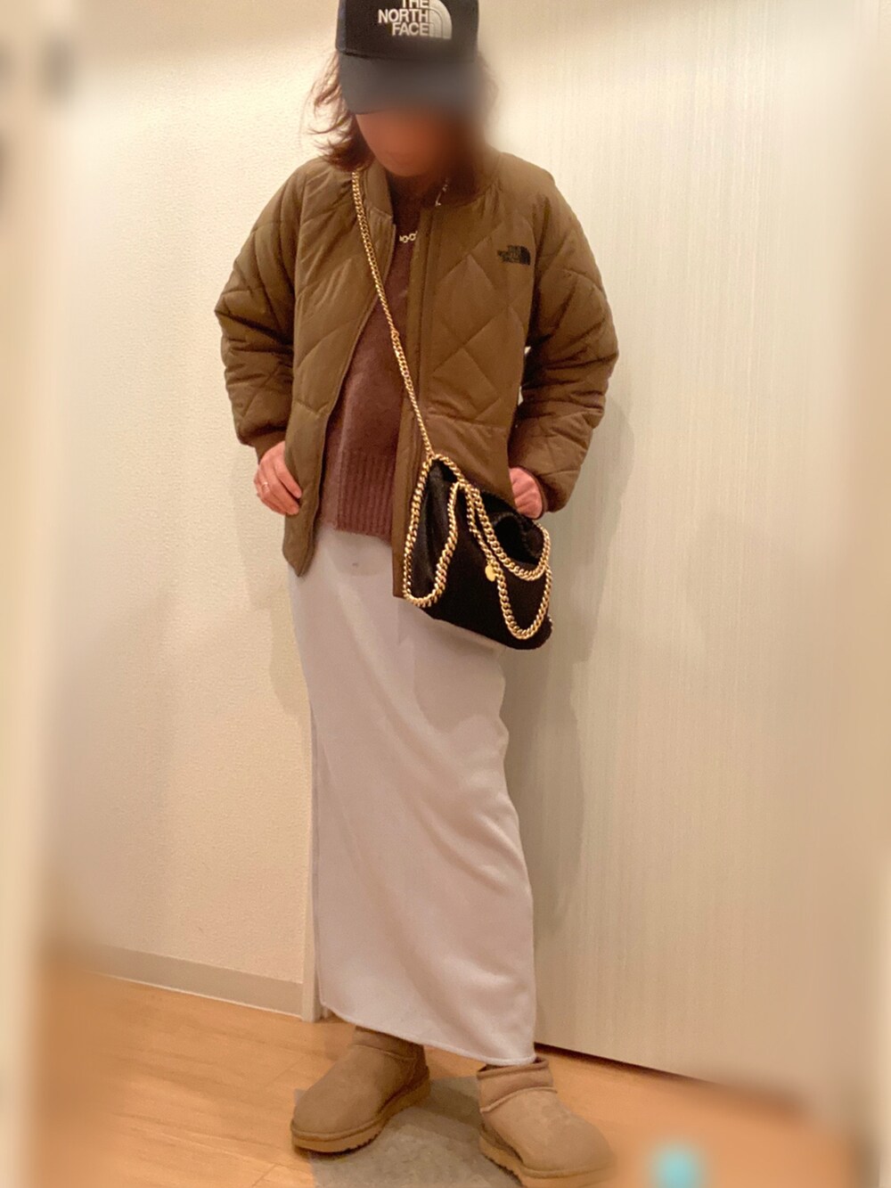 グリーン系のジャケット/アウター、ブラウン系のニット/セーター、ブルー系のスカートを着用したレディースの冬コーディネートの2枚目の写真