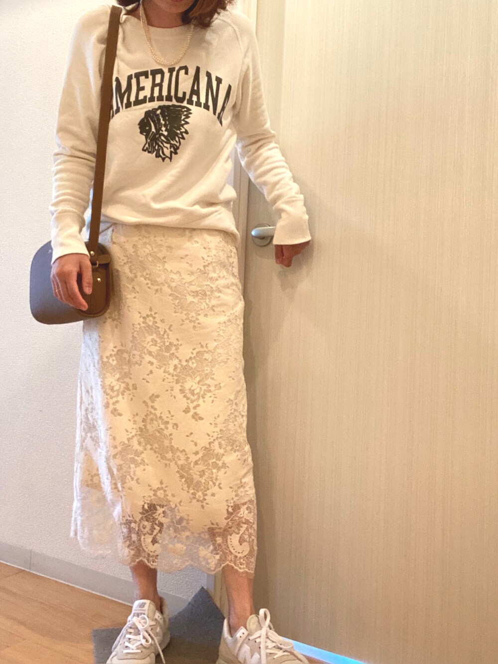 ホワイト系のスカート、グレー系のスニーカー、ベージュ系のショルダーバッグを着用したレディースの春コーディネートの2枚目の写真