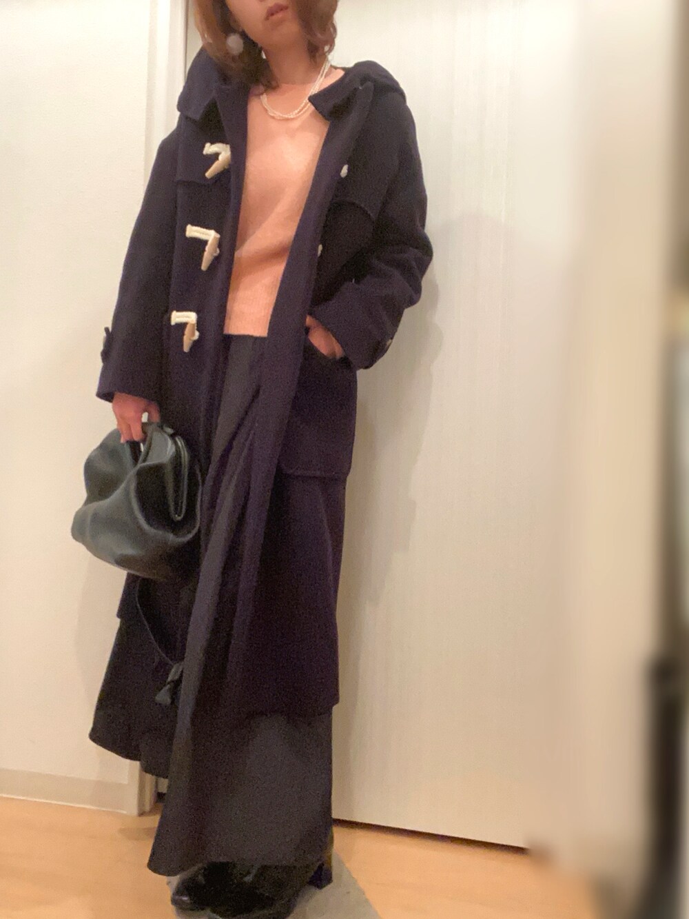 ブルー系のダッフルコート、ピンク系のニット/セーター、ブラック系のスカートを着用したレディースの冬コーディネートの2枚目の写真