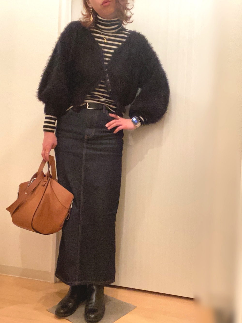 ベージュ系のステンカラーコート、ブラック系のニット/セーター、ブラック系のカーディガン/ボレロを着用したレディースの春コーディネートの2枚目の写真