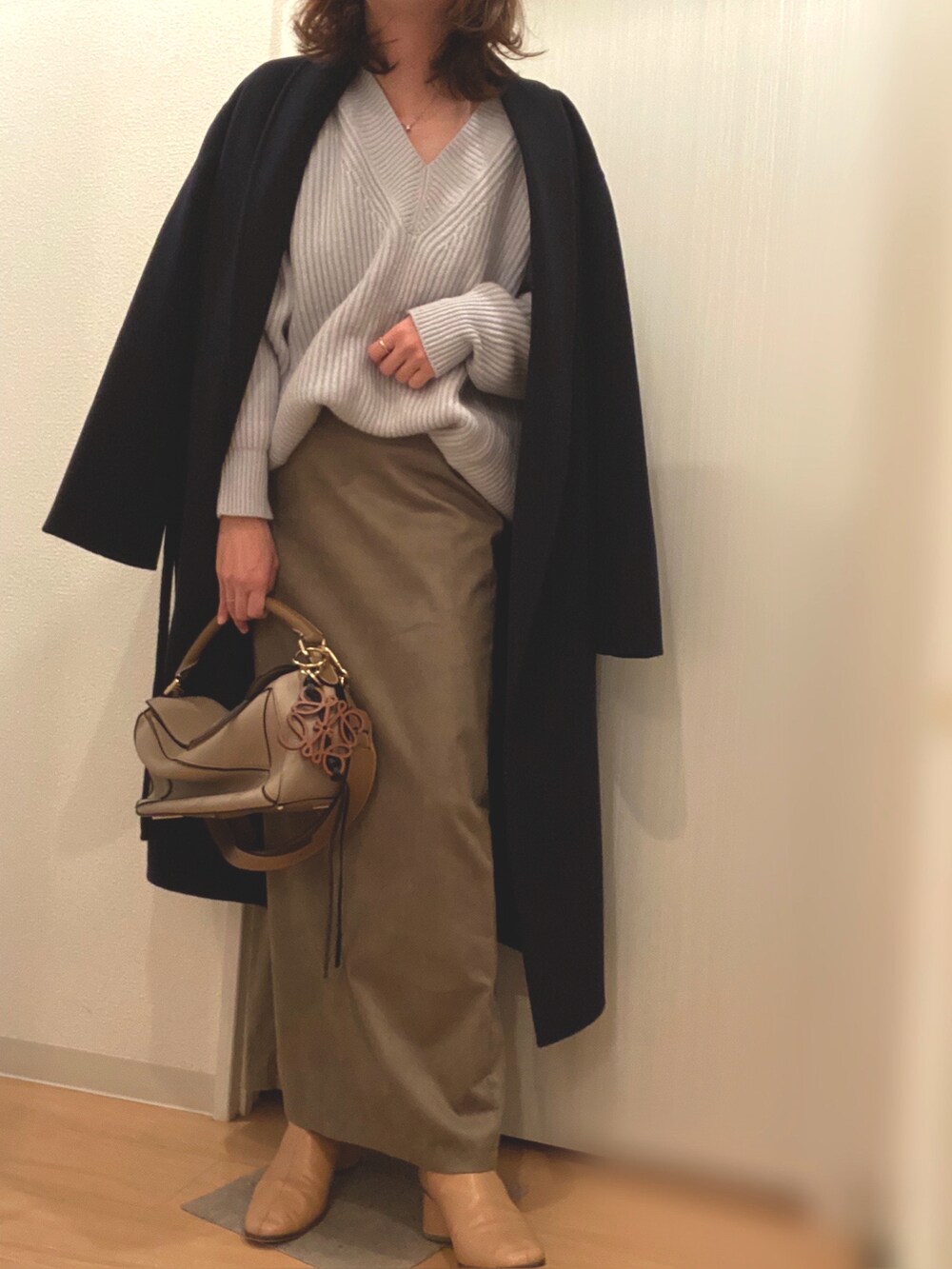 ブルー系のニット/セーター、その他のスカート、ベージュ系のブーツを着用したレディースの冬コーディネートの4枚目の写真