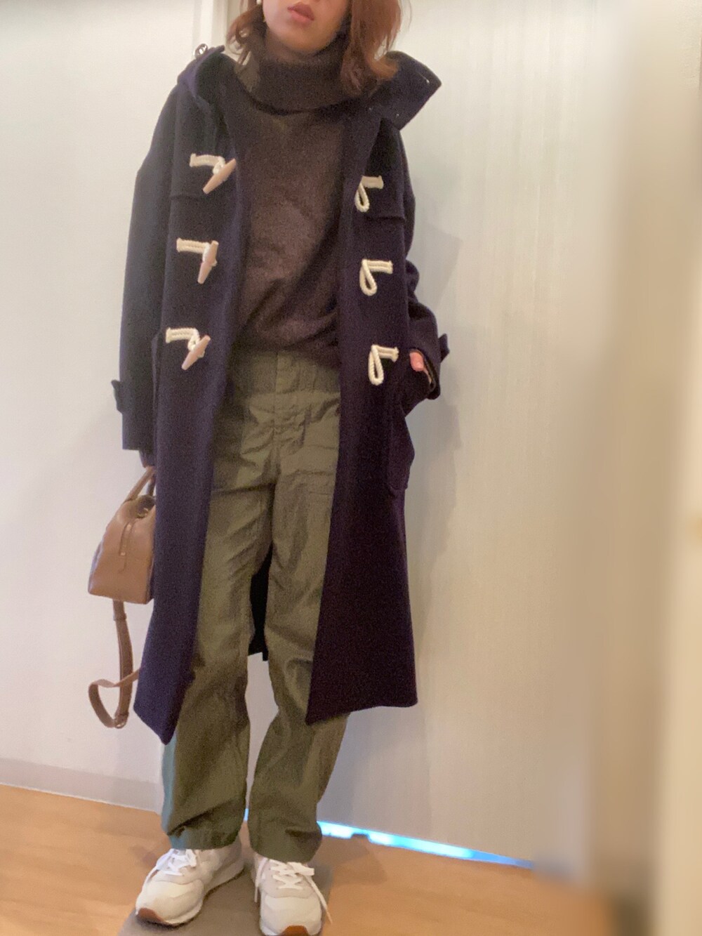 ブルー系のダッフルコート、ブラウン系のニット/セーター、グリーン系のその他パンツを着用したレディースの冬コーディネートの2枚目の写真