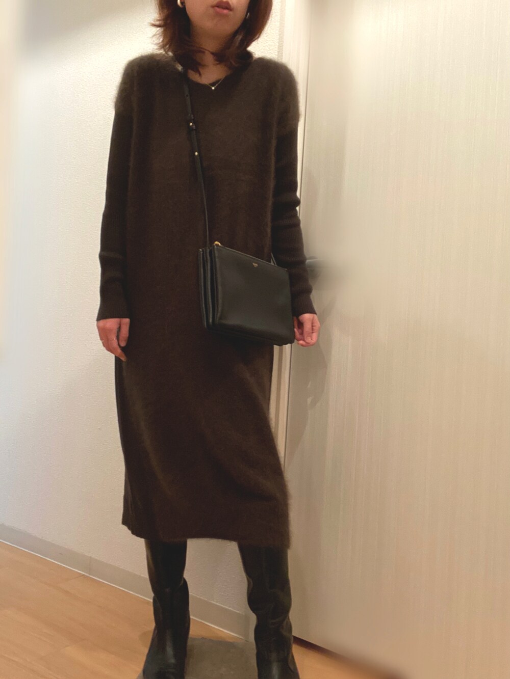 ベージュ系のブルゾン、グリーン系のワンピース、ブラック系のブーツを着用したレディースの冬コーディネートの3枚目の写真