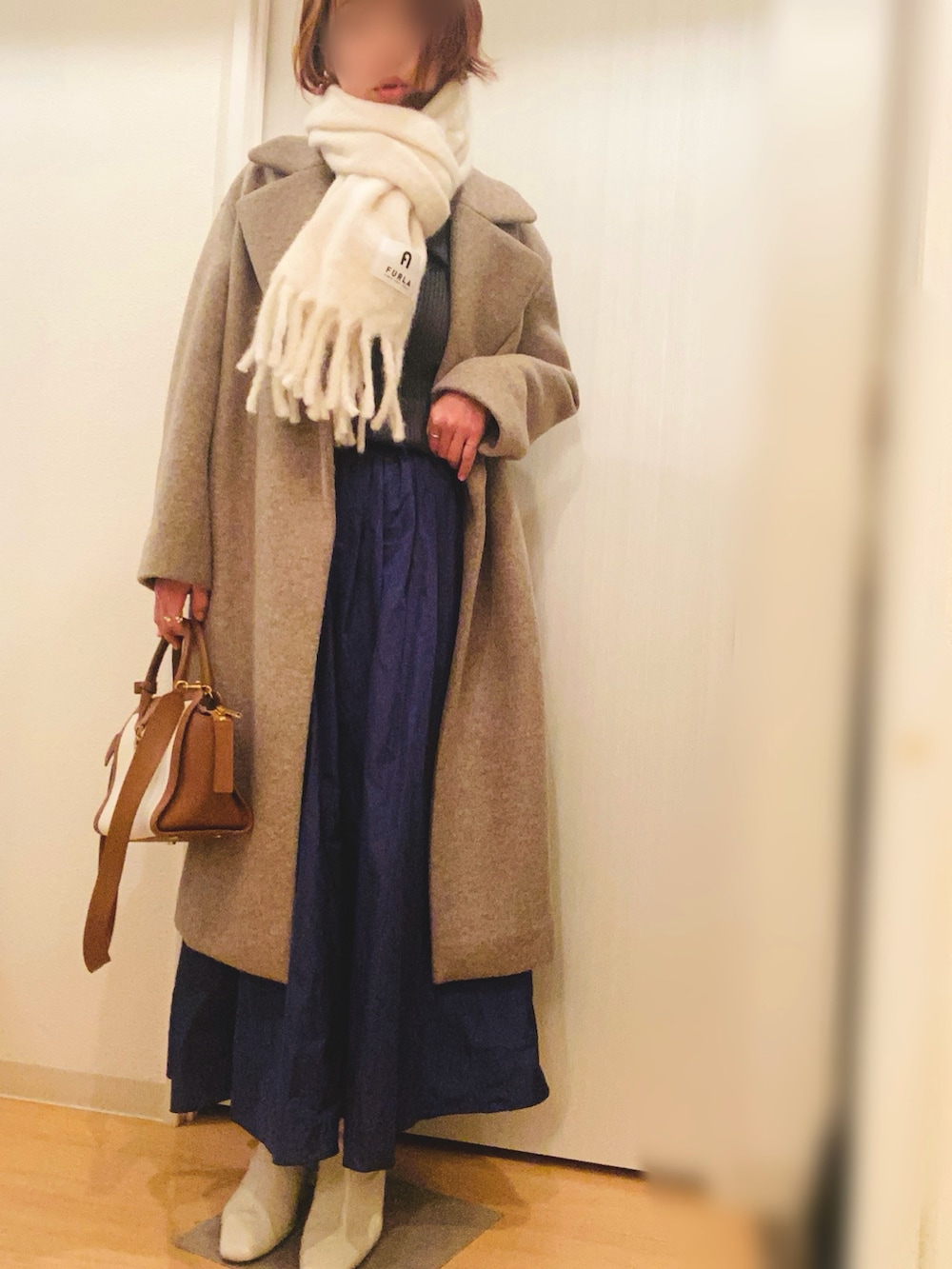 グレー系のニット/セーター、ブルー系のスカート、ベージュ系のブーツを着用したレディースの冬コーディネートの4枚目の写真